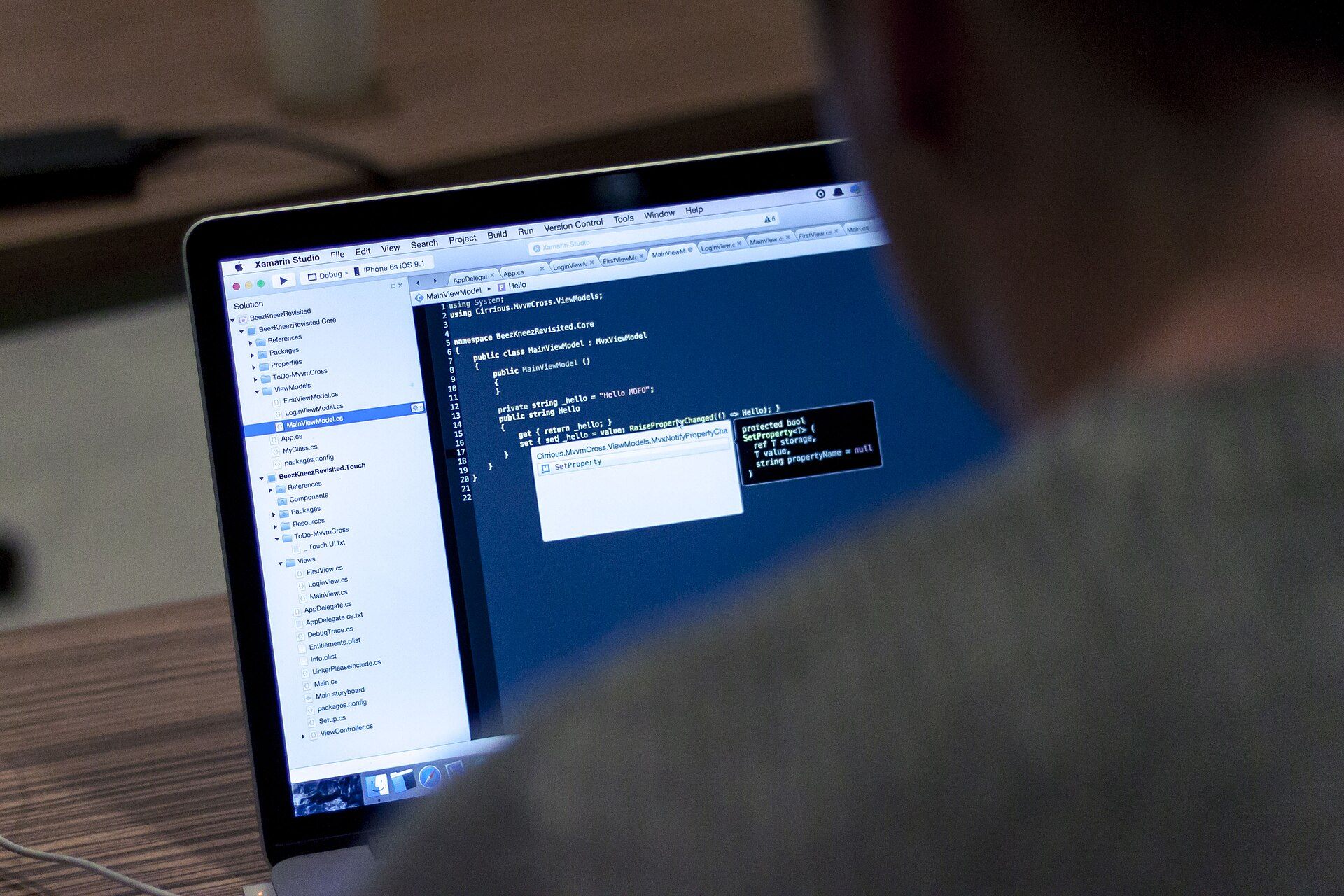 Pessoa trabalhando em um notebook com código de programação na tela